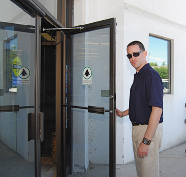 Marc entering a business through an accessible door.