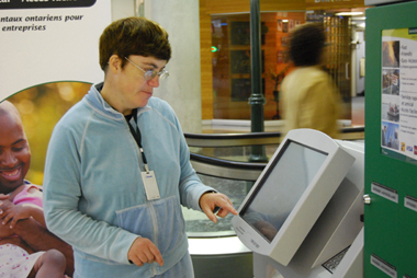 Woman with a developmental disability, using an automated kiosk.